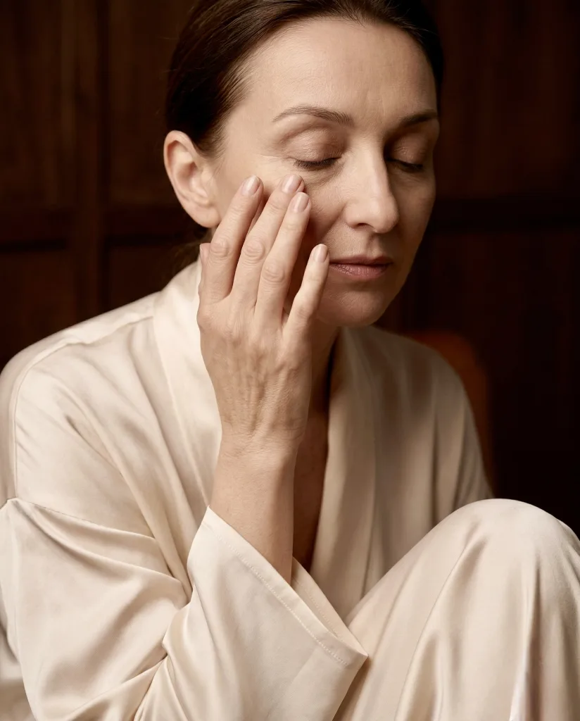 Frau berührt sanft ihre Augenpartie - Wunsch nach Lidstraffung